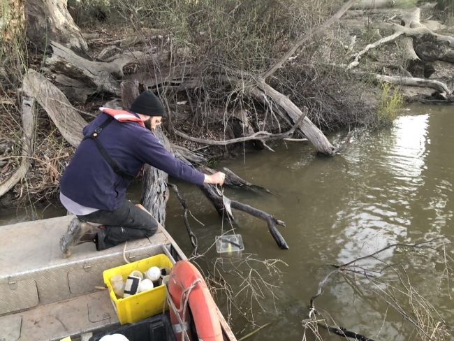 Someone setting a light trap from a boat